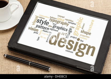 Wolke aus Worten oder Tags, die im Zusammenhang mit Grafik-Design auf einem digitalen Tablet mit einer Tasse Kaffee Stockfoto