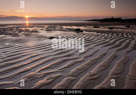 Kräuselt sich der Sand in der Nähe von Dunstanburgh Castle in Embleton Bay bei Sonnenaufgang, Northumberland, England, Vereinigtes Königreich, Europa Stockfoto