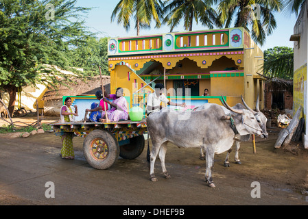 Südindische Menschen auf einem Ochsenkarren vor einem indischen Dorf-Haus. Andhra Pradesh, Indien Stockfoto