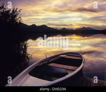 Ruderboot am Hopfensee See bei Sonnenuntergang, in der Nähe von Füssen, Allgäu, Bayern, Deutschland, Europa Stockfoto