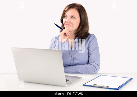 Geschäftsfrau ist vor einem modernen Laptop sitzen und suchen in der oberen Ecke des Bildschirms, Business-Konzept Stockfoto