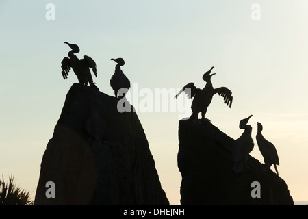 Kormorane Statuen an der Strandpromenade in Morecambe, Lancashire, Silhouette von der untergehenden Sonne, Teil des Kunstwerks "Seeschwalbe Project". Stockfoto