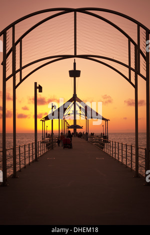 Sonnenuntergang auf einer der wunderschönen Brighton Pier in Australien, ein an der Küste mit kristallklarem Wasser und einem unberührten Sandstrand Stockfoto