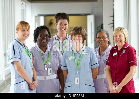 Eine Gruppe von 5 Krankenschwestern Lächeln in Richtung der Kamera in einem Krankenhausflur UK Stockfoto