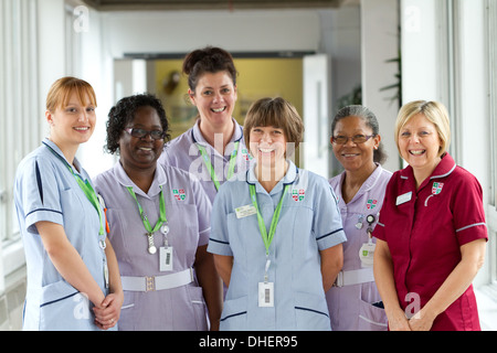 Eine Gruppe von 5 Krankenschwestern Lächeln in Richtung der Kamera in einem Krankenhausflur UK Stockfoto