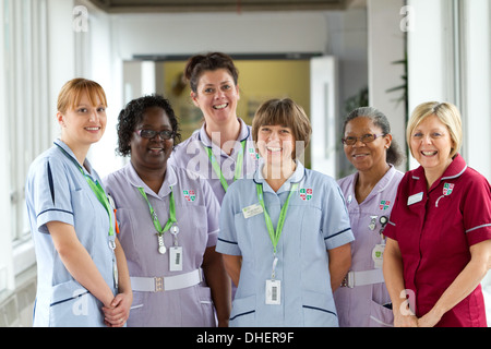 Eine Gruppe von 5 Krankenschwestern Lächeln in Richtung der Kamera in einem Krankenhausflur UK Stockfoto