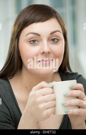 Junge Frau mit einer Kaffeetasse Stockfoto
