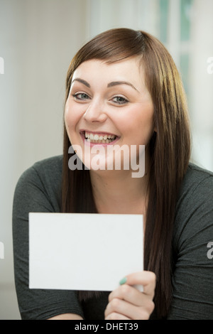 Glückliche junge Frau mit einer leeren Karte Stockfoto