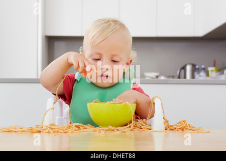 Kleinkind spielt mit spaghetti Stockfoto