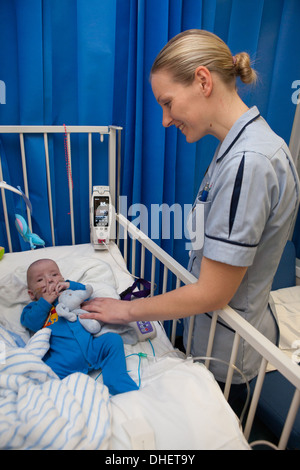 Eine Kinderkrankenschwester kümmert sich um ein Kind in ihrer Obhut UK Stockfoto