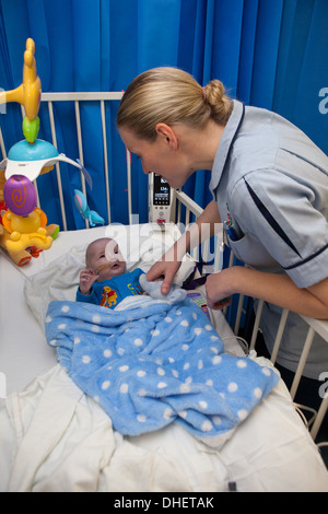 Eine Kinderkrankenschwester kümmert sich um ein Kind in ihrer Obhut UK Stockfoto