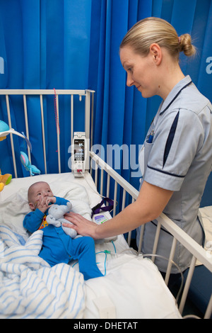 Eine Kinderkrankenschwester kümmert sich um ein Kind in ihrer Obhut UK Stockfoto