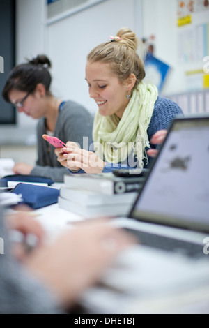 Frau mit Smartphone im Klassenzimmer Stockfoto
