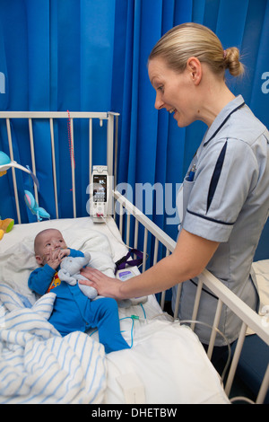 Eine Kinderkrankenschwester kümmert sich um ein Kind in ihrer Obhut UK Stockfoto