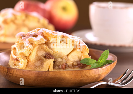 Apfelstrudel mit Rosinen mit Kaffeetasse auf der Rückseite Stockfoto