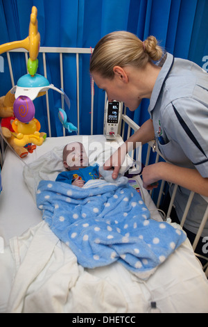 Eine Kinderkrankenschwester kümmert sich um ein Kind in ihrer Obhut UK Stockfoto