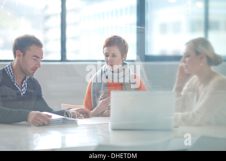 Geschäftsleute sitzen am Konferenztisch Blick auf laptop Stockfoto