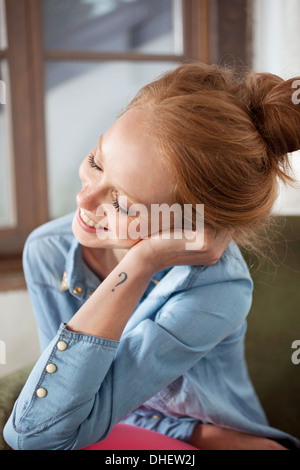 Junge Frau mit Fragezeichen Tattoo lächelnd Stockfoto