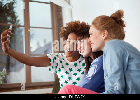Drei Freundinnen fotografieren sich mit Kamera-Handy Stockfoto