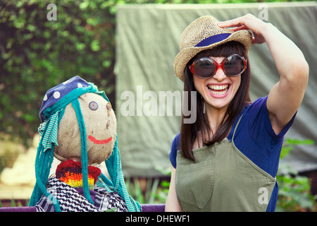 Frau mit Sonnenbrille und Hut mit Vogelscheuche Stockfoto