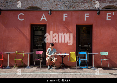 Junger Mann sitzt vor Café, Florenz, Toskana, Italien Stockfoto