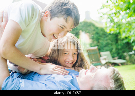 Vater mit Sohn und Tochter spielen im Garten Stockfoto