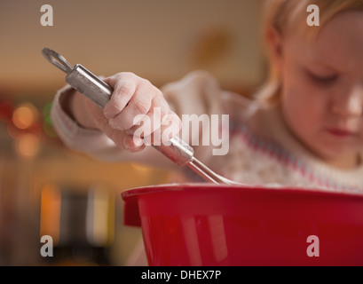 Closeup auf Baby kneten Teig mit Schneebesen Stockfoto