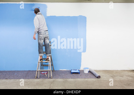 Rückansicht des Mannes Malerei Wand blau Stockfoto