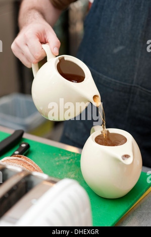 Barista Gießen Tee in der Teekanne mit Eis Stockfoto