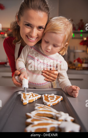 Porträt der glückliche Mutter und Baby Dekoration hausgemachte Weihnachtskekse mit Glasur Stockfoto