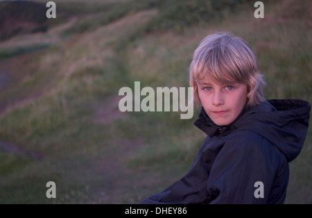 10 Jahre alter Junge, im Freien bei Sonnenuntergang an einem kühlen Sommerabend. Stockfoto