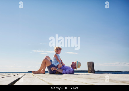 Weibliche Kind und Vater auf Pier, Utvalnas, Hotels, Schweden Stockfoto