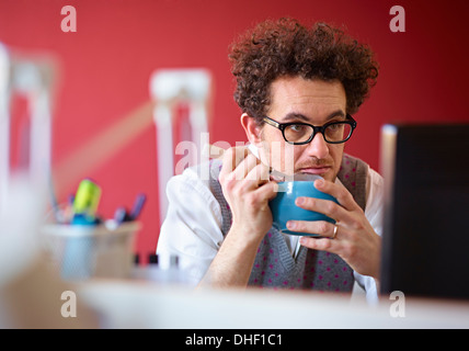 Büroangestellte, Frühstücks-Cerealien am Schreibtisch zu essen Stockfoto