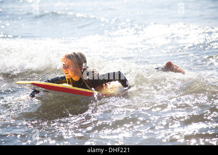 Porträt eines Mädchens auf Surfbrett, Wales, UK Stockfoto