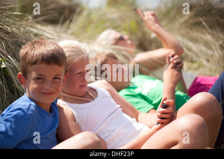 Vier Freunde, die Entspannung in Dünen, Wales, UK Stockfoto