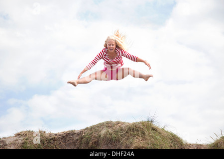 Teenager-Mädchen springen Luft mit Beinen aus Wales, UK Stockfoto