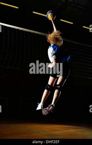 Volleyball-Spieler für Kugel springen, indem Sie net Stockfoto