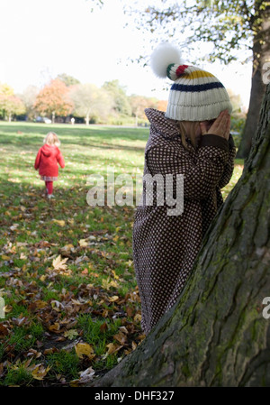 Mädchen spielen verstecken und suchen im Park, London, England, UK Stockfoto