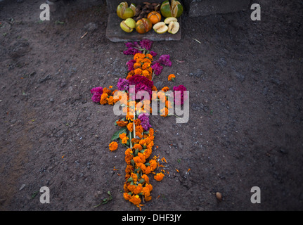 Essen und ein Kreuz aus mit Ringelblumen schmückt ein Grab im Laufe des Tages der Toten in Teotitlan del Valle, Oaxaca, Mexiko Stockfoto