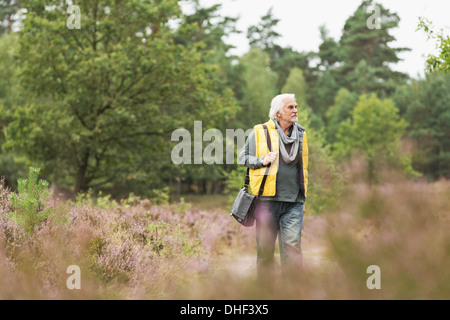 Ältere Mann zu Fuß in Wiese Stockfoto