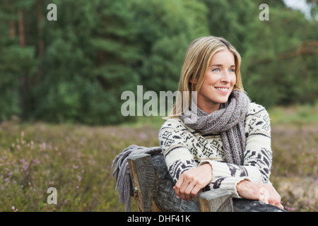 Mitte Erwachsene Frau mit Pullover auf Bank Stockfoto