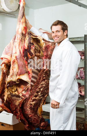 Metzger im Kühler mit Rindfleisch Stockfoto