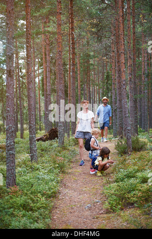 Eltern, die zu Fuß durch Wald mit Töchtern Stockfoto