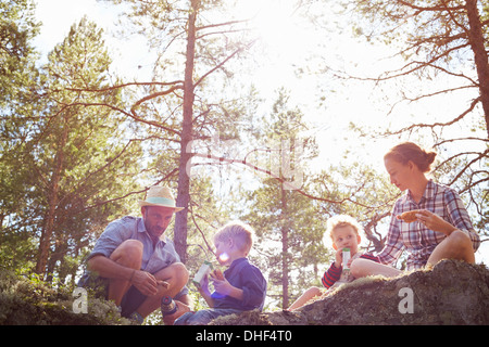 Familie Picknick auf Felsen sitzend Stockfoto