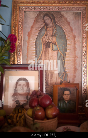 Ein Altar zeigt ein Bild von unserer lieben Frau von Guadalupe, Essen und Familienporträts wird während der Tag der Toten in Oaxaca angezeigt. Stockfoto