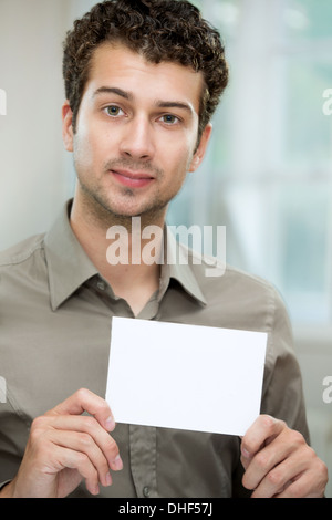 Junger Mann halten weiße Karte Stockfoto