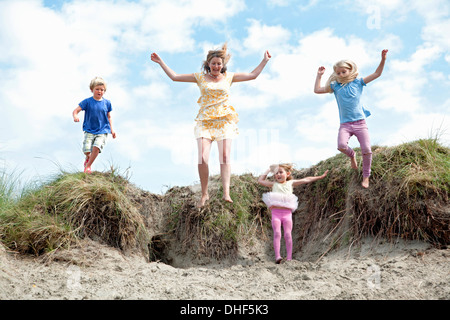 Mutter mit drei Kindern abspringen Dünen, Wales, UK Stockfoto