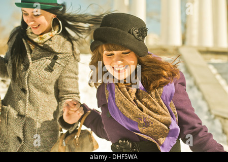 Zwei junge Frauen laufen im Schnee Stockfoto