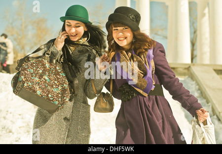 Zwei junge Frauen, Tragetaschen im Schnee Stockfoto