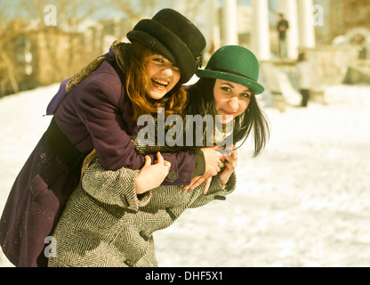 Zwei junge Frauen herumalbern im Schnee Stockfoto